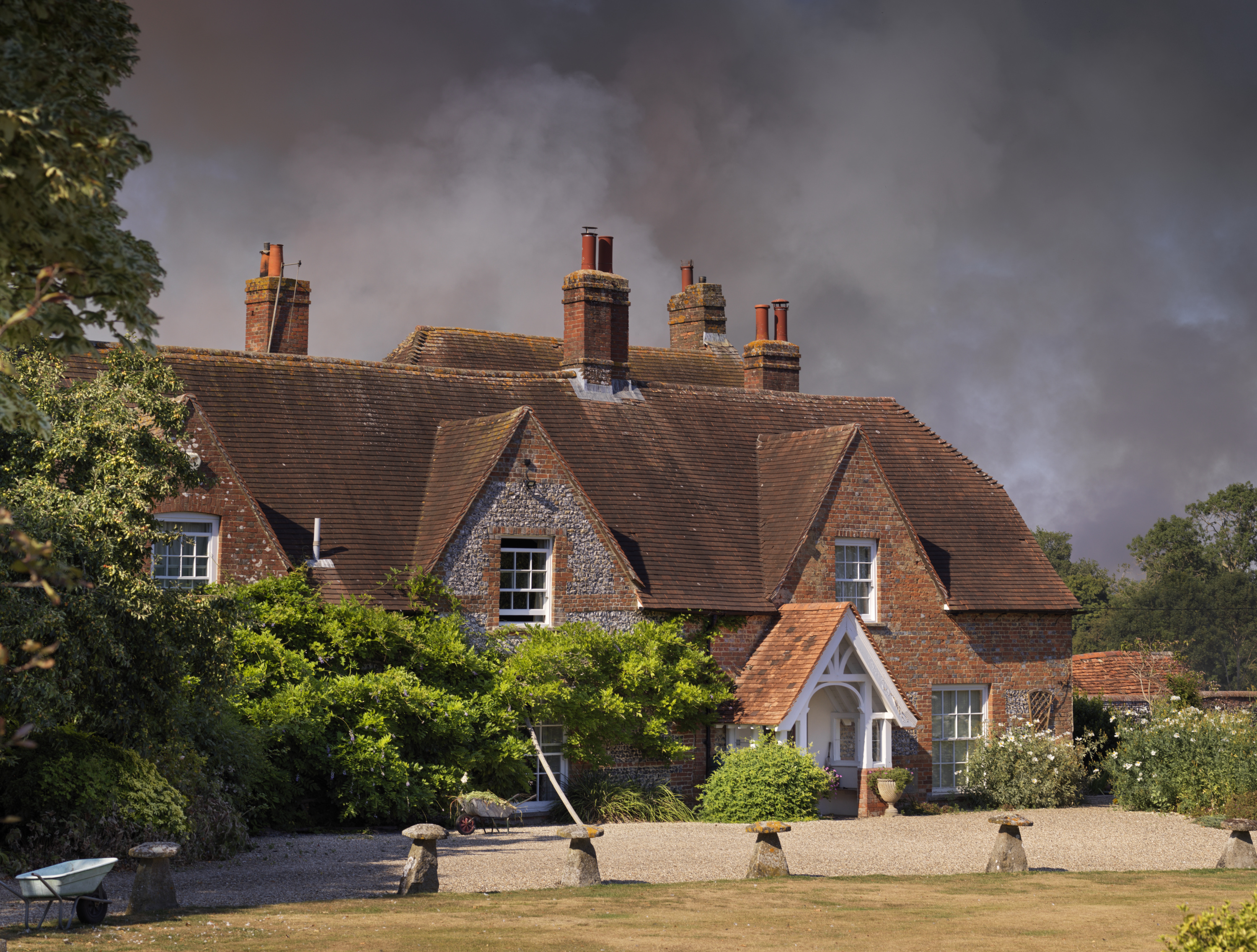 A house with smoke rising behind it.